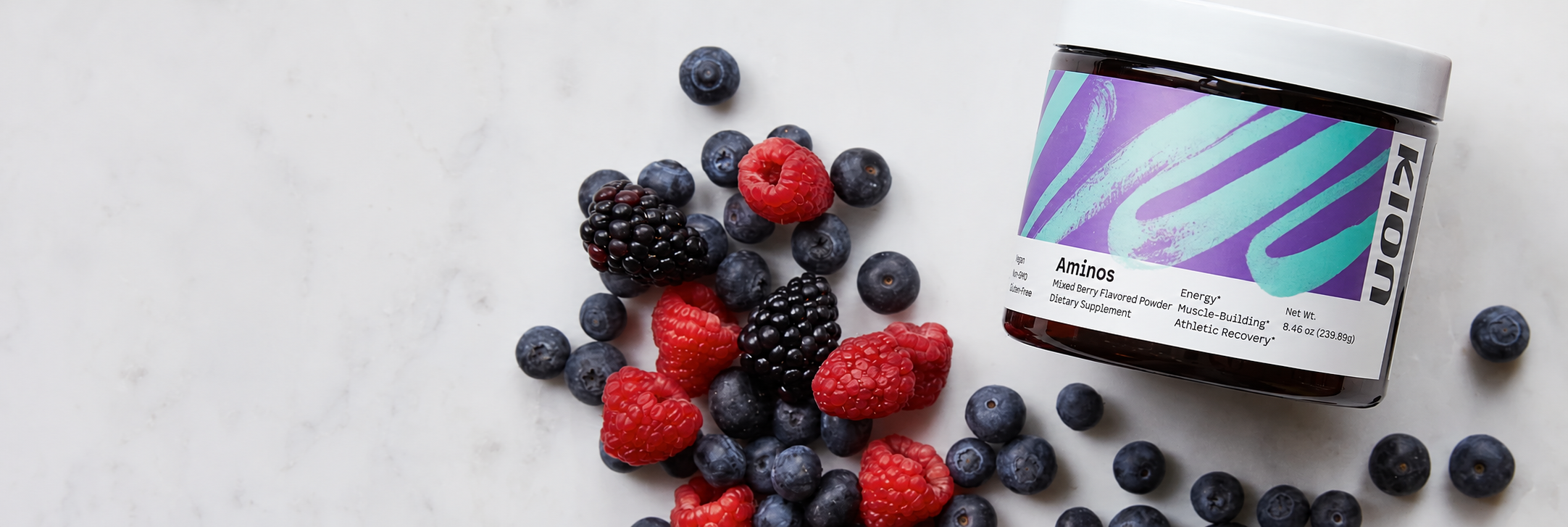Kion Mixed Berry Aminos with fresh berries on a light surface